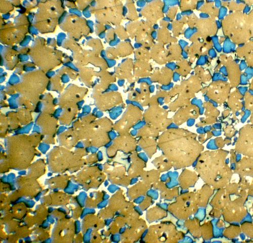 Microscopic clinker section, polished and etched, showing alite in brown and belite in blue