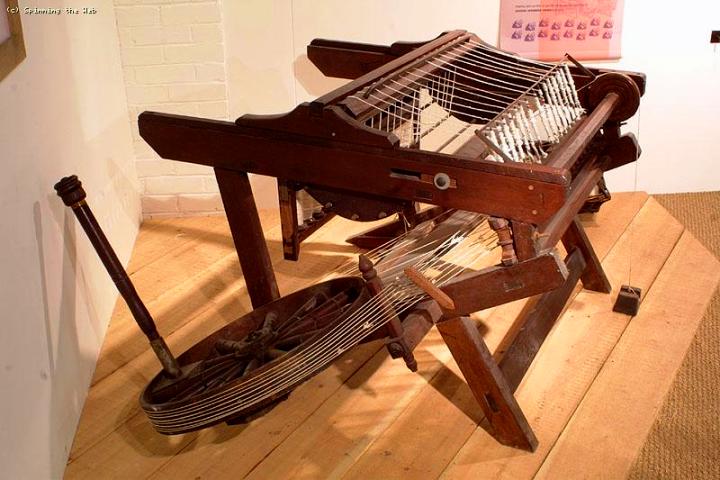 Spinning jenny. Note the sideways wheel and multiple, vertical spindles